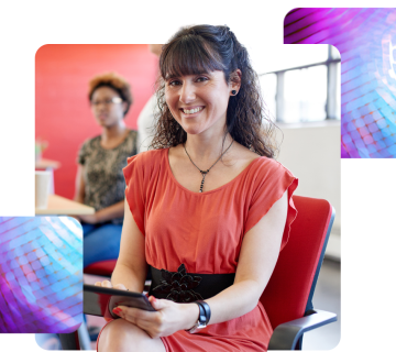 a lady sat on a chair, smiling holding a tablet.