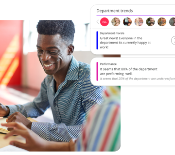 a man sat at a table working, smiling. with People First department trends displaying.