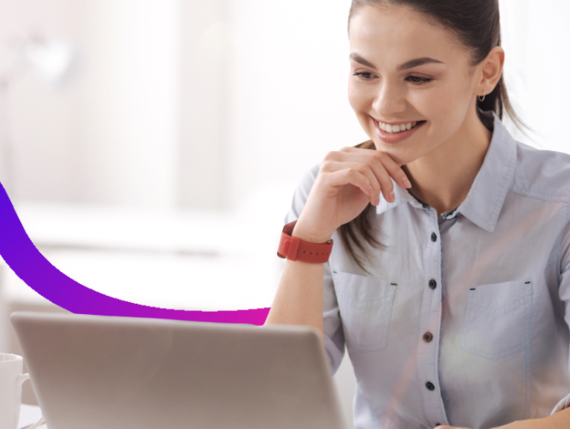 Smiling woman works on a laptop at a desk