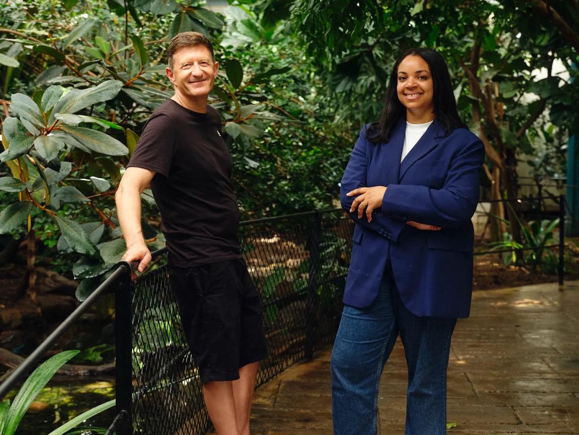 Keith Day and Osha Daley stand in front of an enclosure at London Zoo.
