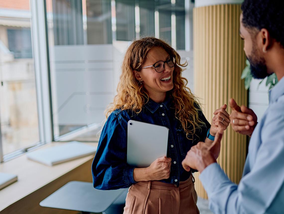 Two people in an office discussing payroll.