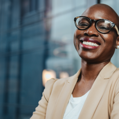 A woman wearing glasses, smiling.
