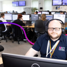 Man at a computer wearing a delt shared services uniform