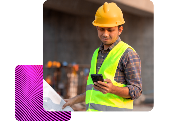 A man wearing a hard hat in a construction yard, clocking in remotely through people first hr software