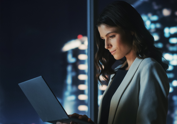 Woman in working environment looking at laptop screen