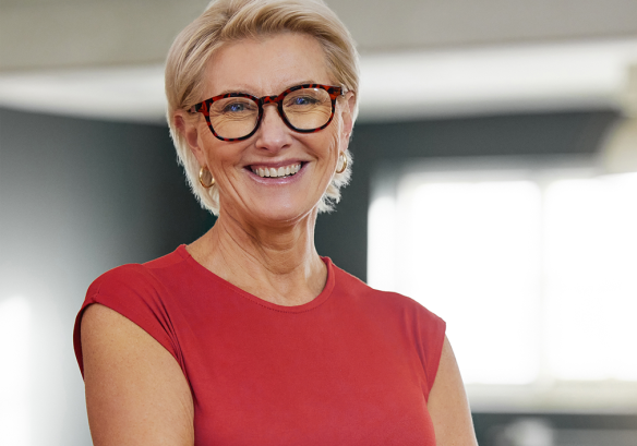 Senior woman with glasses and red top smiling