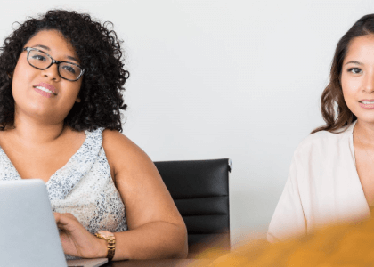 Two people looking happy and content to be in work environment