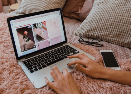Person working from home crouched on bed with laptop