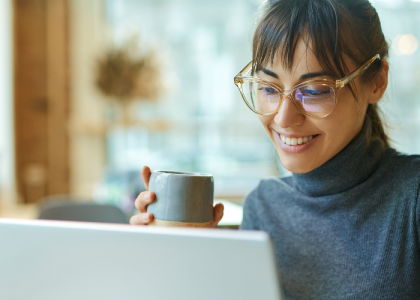 Woman smiling looking at learning on laptop screen