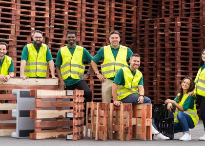 An image of IPP employees in hi viz surrounded by pallets. 