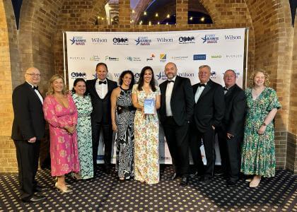 Chairman Jessica Mills holding the Family Business of the Year award, surrounded by other executives