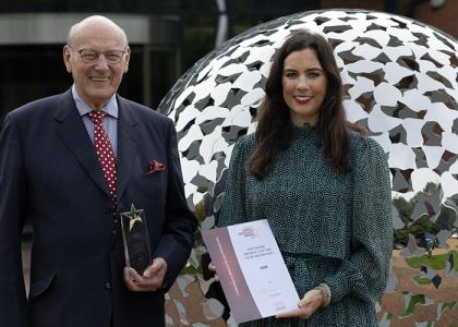 Mr John Mills and Ms Jessica Mills in front of the MHR head office holding the CIPP Software Product of the Year 2023 award. 