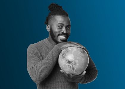 A man holding a globe smiling.