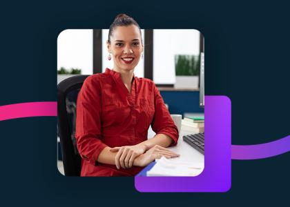 Woman in a red shirt sitting at her desk.