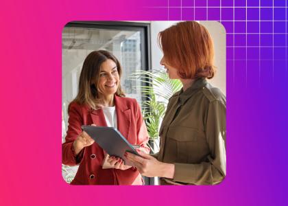 Two women having a conversation looking at a tablet.