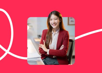 Image of a woman at a desk against a red background