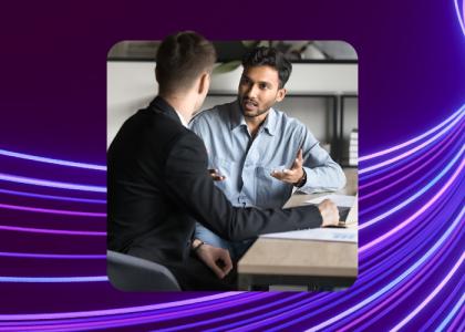 Two colleagues talking at desk in office