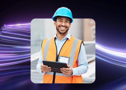 A construction worker in a hivis and hardhat. on an ipad.
