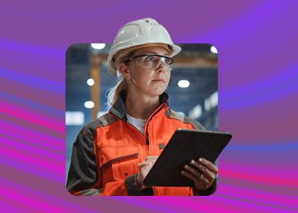 Female construction worker wearing a safety helmet and holding a clipboard