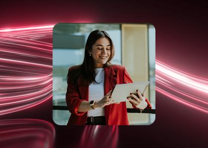 A small business manager smiling at a handheld tablet.