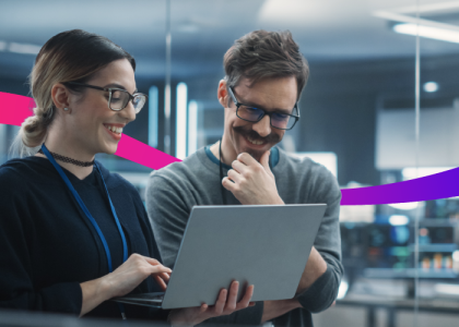 two people looking at a laptop