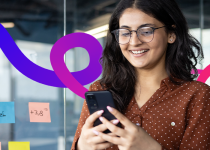 Women stood looking at phone in the office