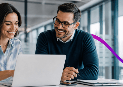 two people looking at a laptop