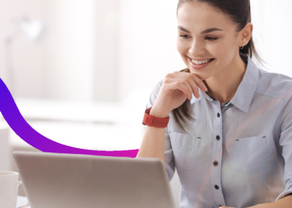 Smiling woman works on a laptop at a desk
