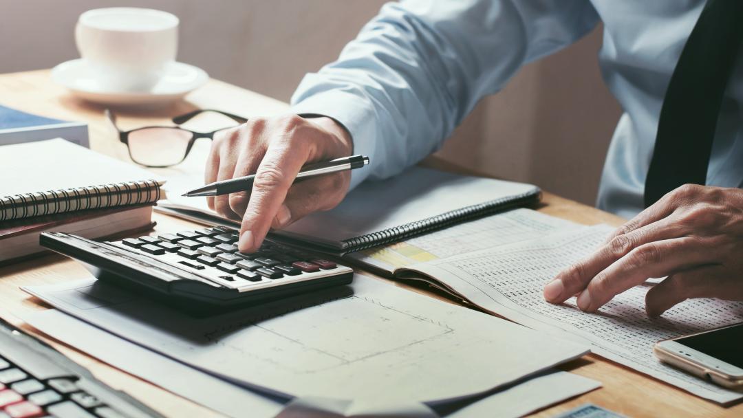 Finance worker calculating sums at desk
