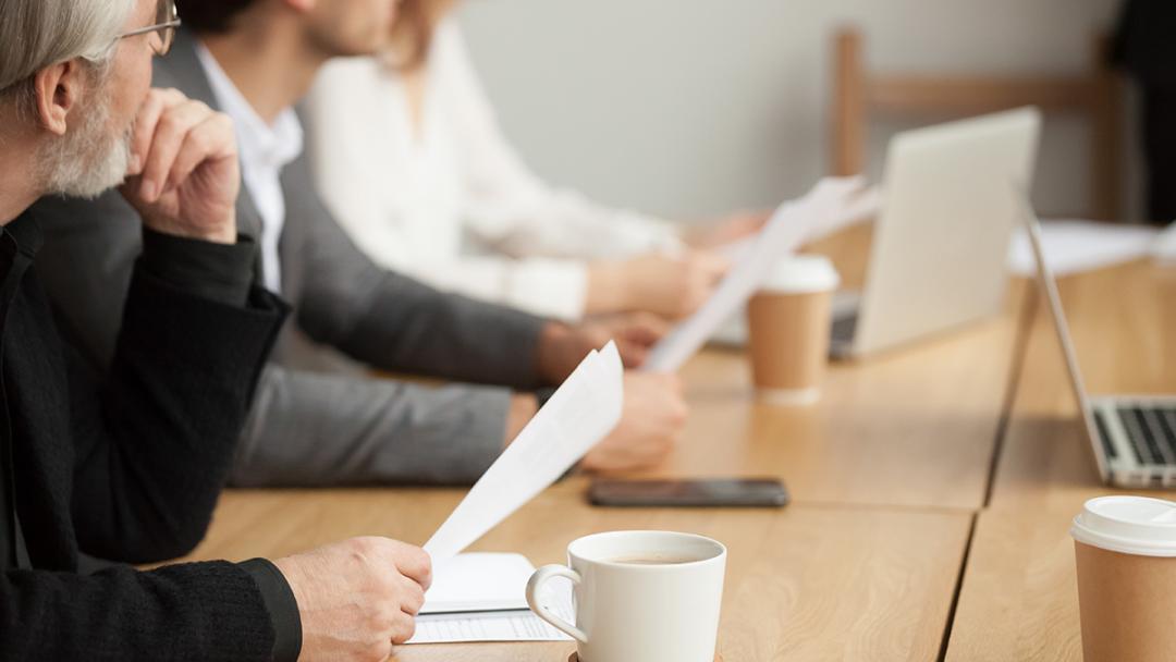 Business people sat around a table having a meeting
