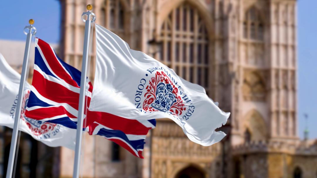 The Union Flag and Coronation logo flying near Westminster Abbey to celebrate the coronation of King Charles