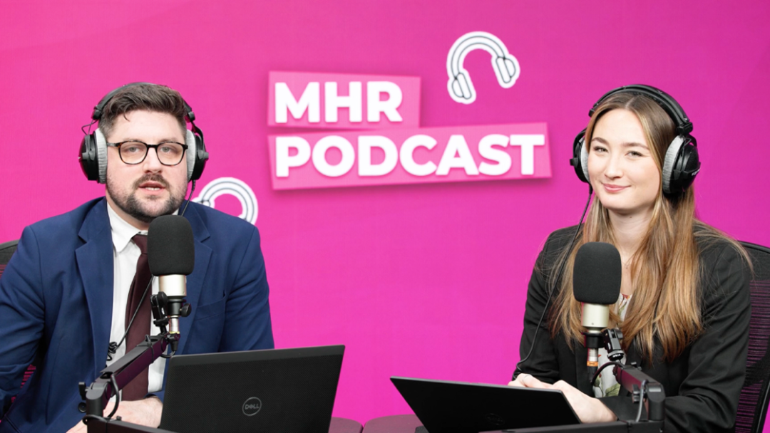 Alice and Andy sat with headphones on infront of a mic and laptop, with MHR podcast written behind them.