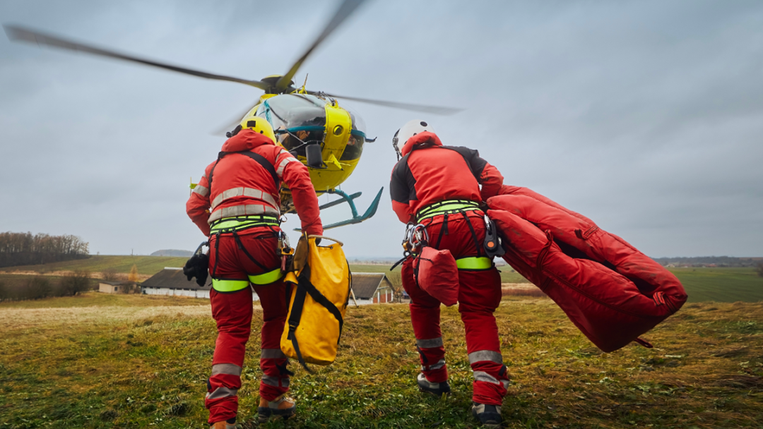 An emergency team running towards a helicopter.