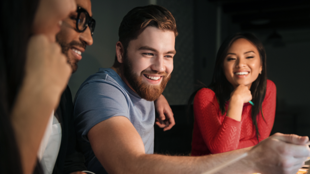 Four people sat on a table, smiling.