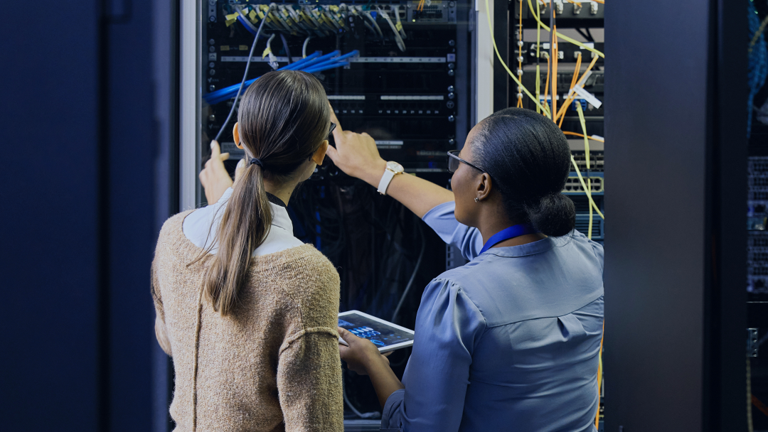 two women looking at a data server