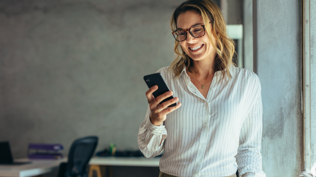 person smiling whilst looking at phone
