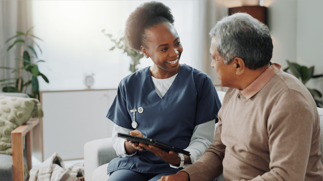 Healthcare professional supporting a patient while using a tablet