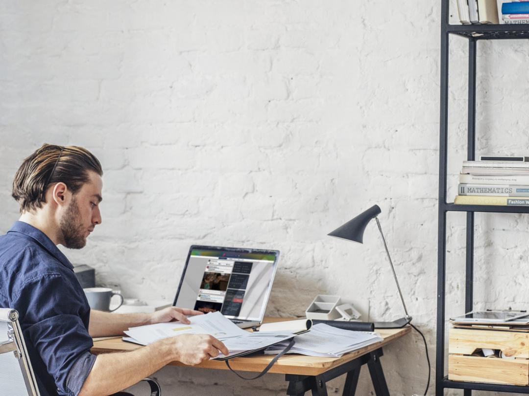 Man at desk using People First social feed