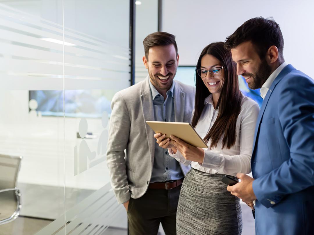 A group of colleagues looking at a tablet to plan their workforce for the future.