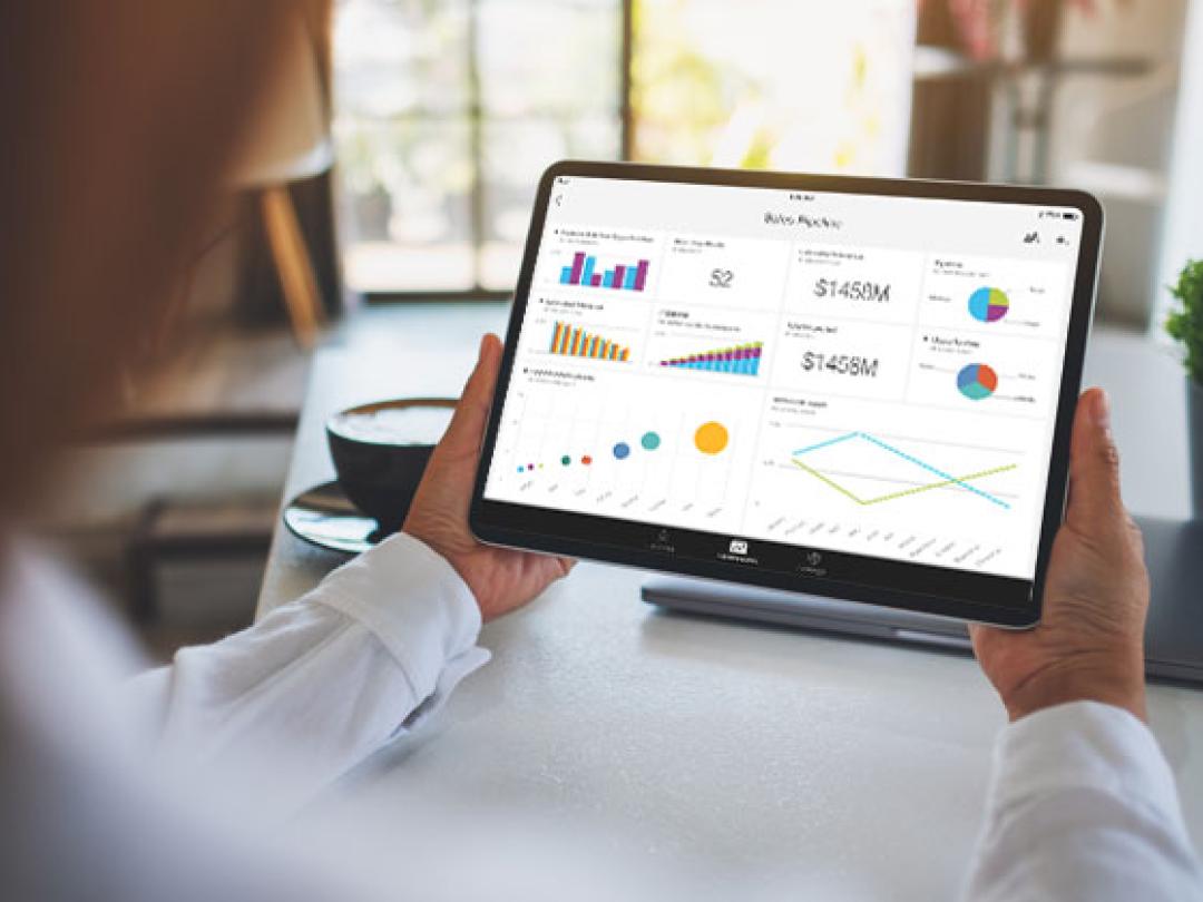 arms holiday a tablet showing Power BI on the screen