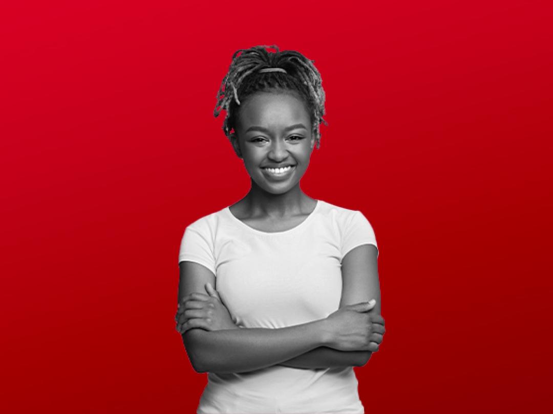 A lady with a white t-shirt on, crossing her arms smiling.
