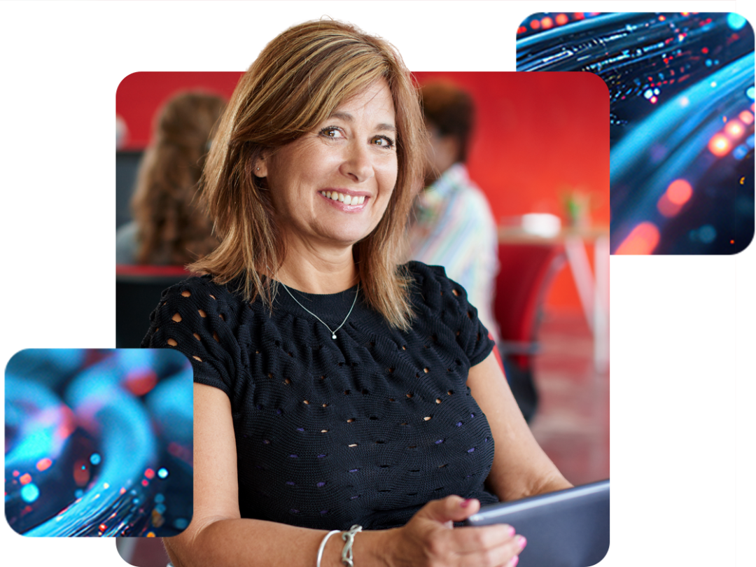 a lady sat smiling with a laptop on her lap.