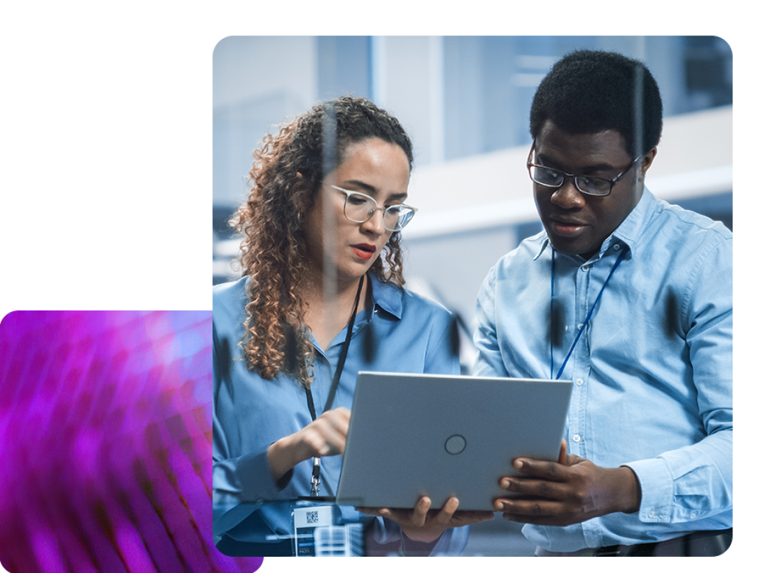 A man and a woman looking at a laptop collaborating over payroll software.