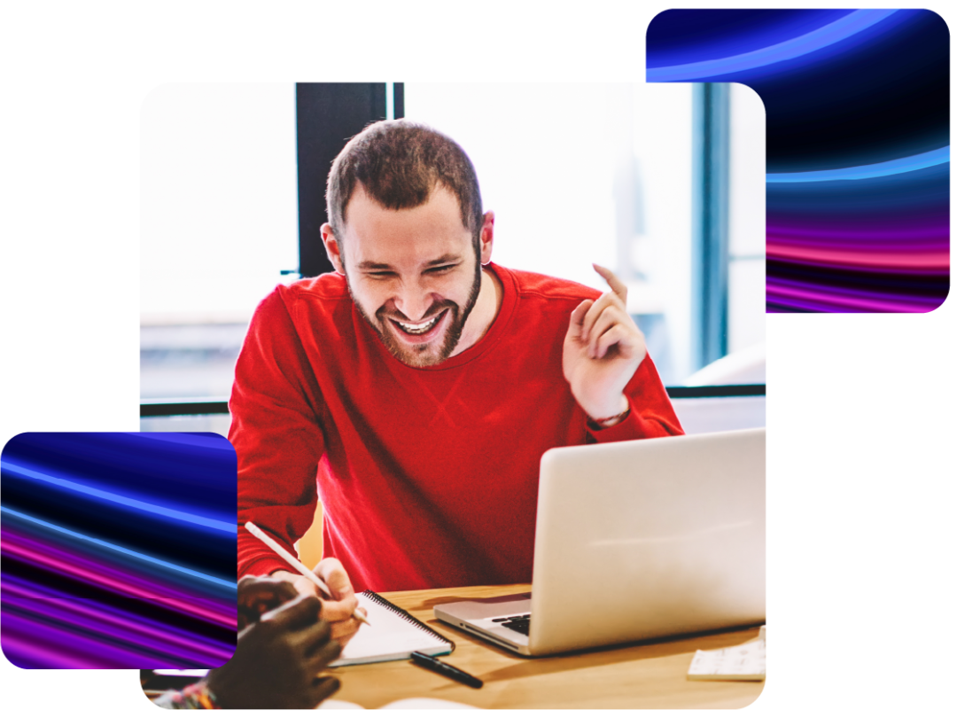 A man laughing at his laptop.