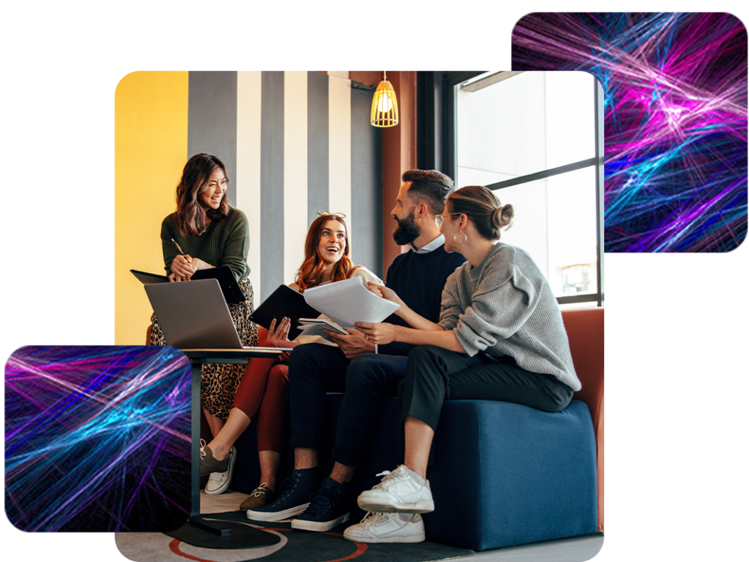 A group of people working in an office, holding notebooks and sitting with a laptop infront of them.