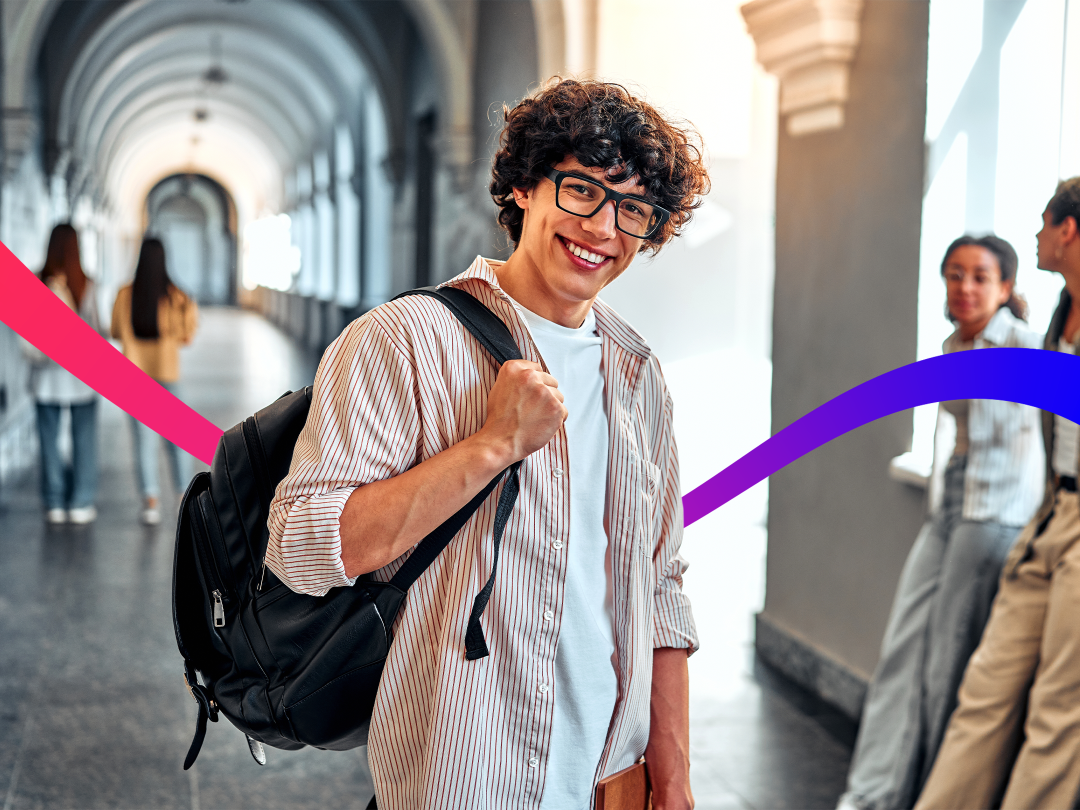 Man with bag on his bag smiling in the hall of a higher education institute