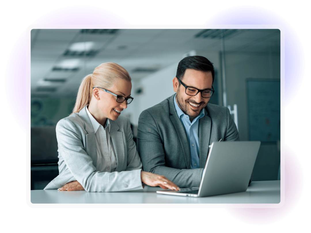 Two colleagues reviewing information together on a laptop in an office