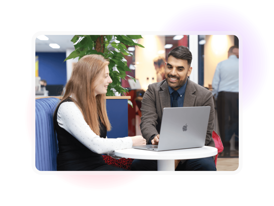 Two colleagues reviewing information together on a laptop