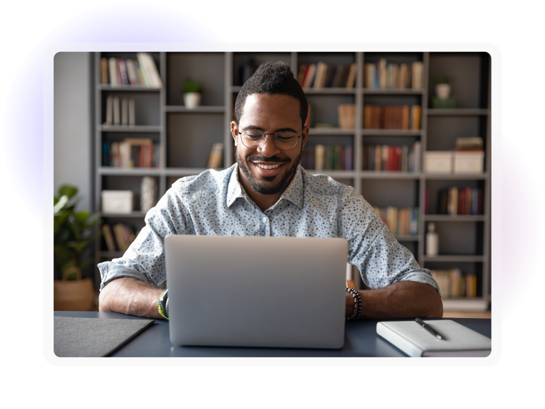Business professional smiling whilst using a laptop