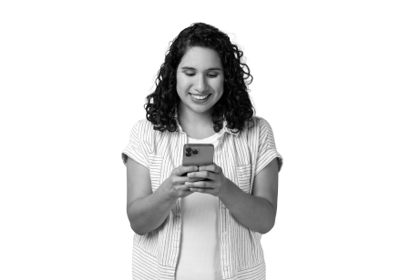 A lady stood with her phone, smiling over MHR's data quality and delivery through Microsoft dynamics.